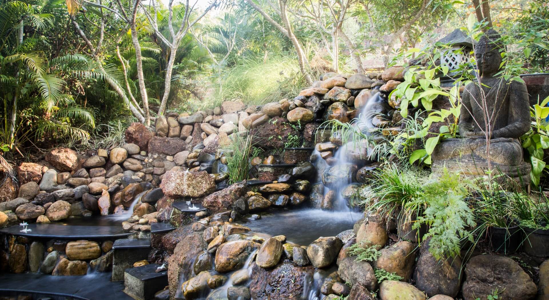 A serene Buddha meditates among the waterfalls